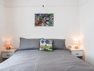 a bedroom with a bed and two nightstands with two lamps at Sunnyside in Colchester