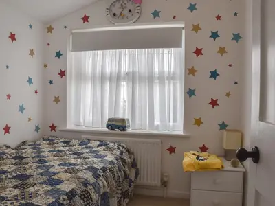 a bedroom with a bed with stars on the wall at Sunnyside in Colchester