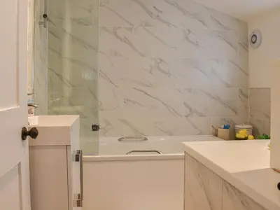 a white bathroom with a tub and a sink at Sunnyside in Colchester