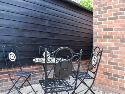 two chairs and a table in front of a brick wall at Sunnyside in Colchester
