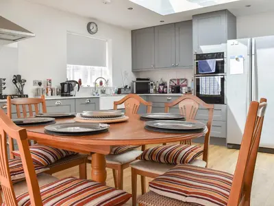 a kitchen and dining room with a wooden table and chairs at Sunnyside in Colchester