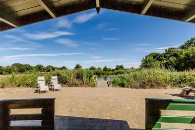 a view of a patio with chairs and a table at Cottage In Norfolk Sleeps 23 - Private Pool, Fishing Lake, Hot Tub Ref 99008Sc in Hockham