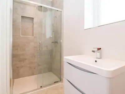 a white bathroom with a shower and a sink at Town Farm House, Orford in Orford
