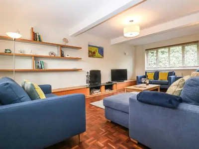 a living room with two blue couches and a tv at Town Farm House, Orford in Orford