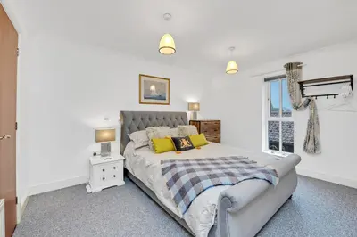a white bedroom with a bed and a window at 10 St Edmundsbury Mews in Bury Saint Edmunds