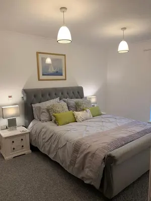 a bedroom with a large bed with two lamps at 10 St Edmundsbury Mews in Bury Saint Edmunds