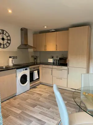 a kitchen with a washer and dryer and a table at 10 St Edmundsbury Mews in Bury Saint Edmunds