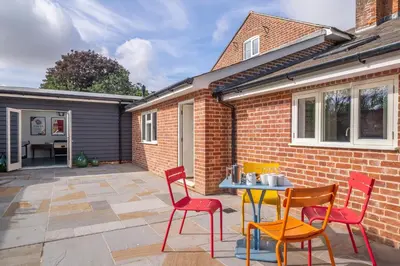 a patio with two chairs and a table and chairs at Luxurious rural retreat - Holt Coach House in Sudbury