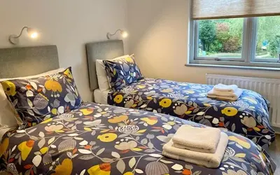 a bedroom with two beds with flowers on them at 72 Ashley Road in Newmarket