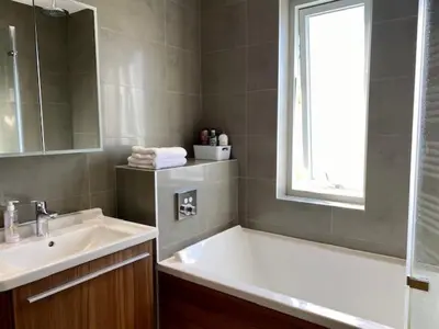 a bathroom with a tub and a sink and a window at 72 Ashley Road in Newmarket