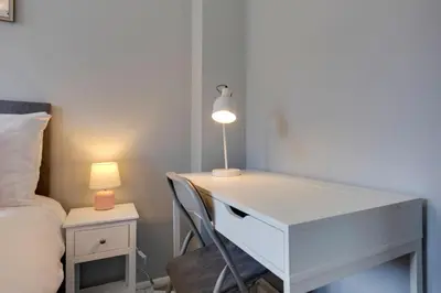 a white desk with a lamp next to a bed at Pass the Keys Renovated Sunny Home Pass the Keys in Cambridge