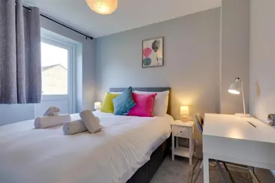 a bedroom with a large white bed with colorful pillows at Pass the Keys Renovated Sunny Home Pass the Keys in Cambridge