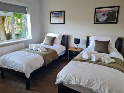 a bedroom with two beds and a window at The Farmhouse - Linton Horseheath in Linton