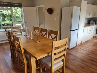 a wooden dining room table with chairs and a refrigerator at The Farmhouse - Linton Horseheath in Linton