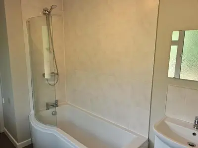 a bathroom with a white tub and a sink at The Farmhouse - Linton Horseheath in Linton