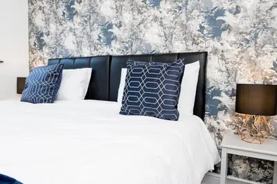 a bedroom with a bed with blue and white pillows at Modern and Spacious 4 Bedroom Home in Ipswich in Ipswich