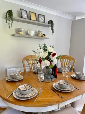 a dining room table with plates and wine glasses at Charming 2 Bedroom Bungalow with open plan living in Felixstowe