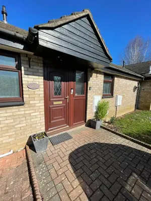 a house with a red door and a brick driveway at Charming 2 Bedroom Bungalow with open plan living in Felixstowe