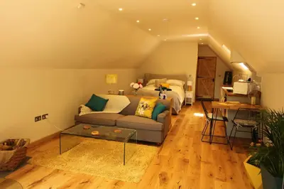 a living room with a couch and a bed at The Hive - beautiful studio with amazing hot tub in Cratfield