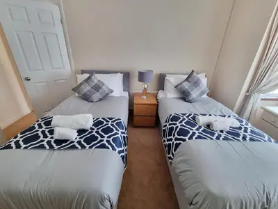 two twin beds in a room with a window at Contractors Home from Home in South Benfleet
