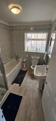 a bathroom with a tub and a toilet and a sink at Contractors Home from Home in South Benfleet