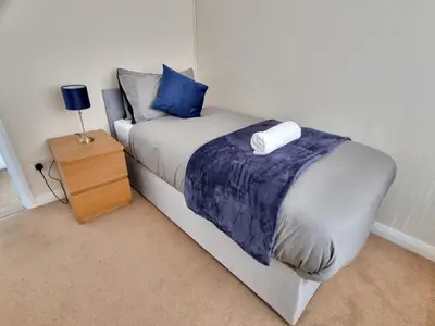 a bedroom with a bed and a night stand at Contractors Home from Home in South Benfleet
