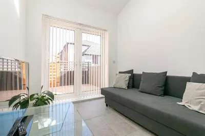a living room with a couch and a glass table at King Pin Corner in Stevenage
