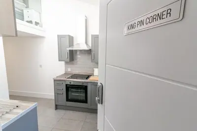 a kitchen with a stove and a door with a sign on it at King Pin Corner in Stevenage