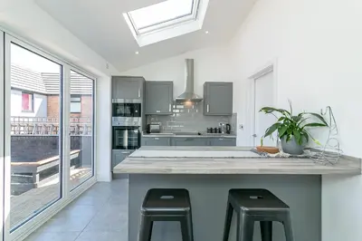 a kitchen with a large island with stools at Archers House in Stevenage