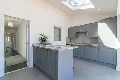 a kitchen with gray cabinets and a sink at Archers House in Stevenage