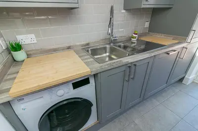 a kitchen with a sink and a washing machine at Archers House in Stevenage