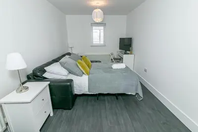 a bedroom with a bed and a desk with a lamp at Archers House in Stevenage