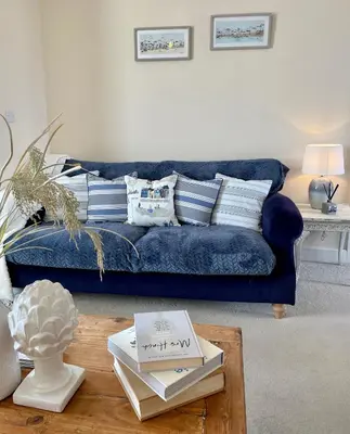 a blue couch in a living room with a coffee table at Luxurious Beach House with spectacular sea views in Felixstowe