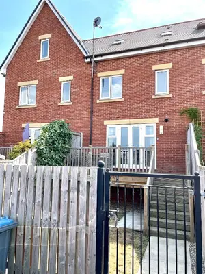 a red brick house with a wooden fence in front of it at Luxurious Beach House with spectacular sea views in Felixstowe