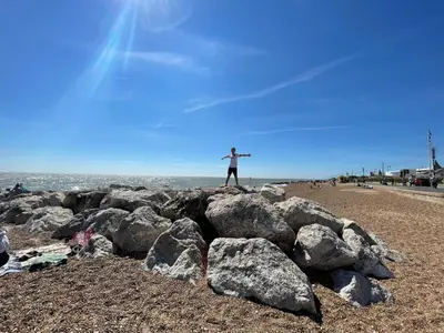 a person standing on a pile of rocks on the beach at Luxurious Beach House with spectacular sea views in Felixstowe