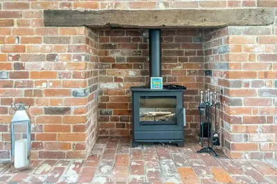 a brick wall with a stove in a brick wall at Stripe Cottage - Aldeburgh Coastal Cottages in Aldeburgh