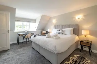 a bedroom with a large white bed and a desk at Stripe Cottage - Aldeburgh Coastal Cottages in Aldeburgh