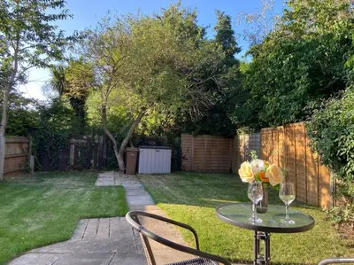 a table with two chairs and a vase of flowers on it at Cosy Bungalow Near Open Countryside in Felixstowe