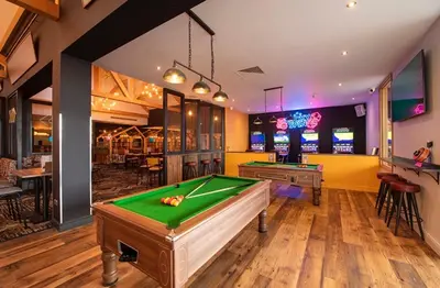 a room with a pool table and arcade games at 1 Martello Beach 8 berth holiday home with pools in Clacton-on-Sea
