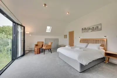 a bedroom with a large bed and a large window at 5 Bed in Aldeburgh oc-pops in Aldeburgh