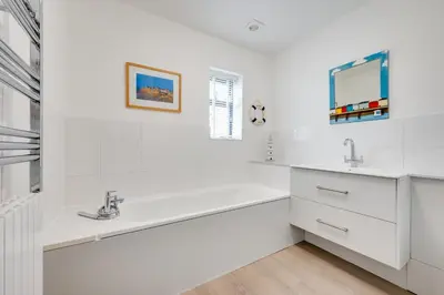 a white bathroom with a tub and a sink at 5 Bed in Aldeburgh oc-pops in Aldeburgh