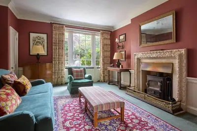 a living room with a blue couch and a fireplace at Abbey House by Group Retreats in Saffron Walden