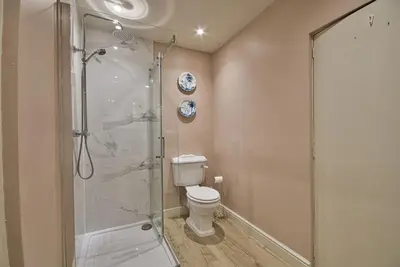 a bathroom with a toilet and a glass shower at Abbey House by Group Retreats in Saffron Walden