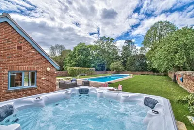 a swimming pool in the backyard of a house at Abbey House by Group Retreats in Saffron Walden