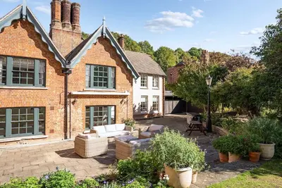 a brick house with a patio in front of it at Abbey House by Group Retreats in Saffron Walden