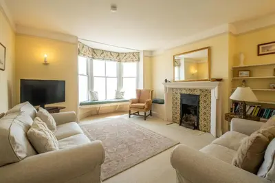 a living room with a couch and a fireplace at Shore View, Aldeburgh - A lovely Seafront House on famous Crag Path with uninterrupted Beach Views - Aldeburgh Coastal Cottages in Aldeburgh