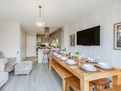 a living room with a wooden table with plates and wine glasses at Violet Place in Broomfield