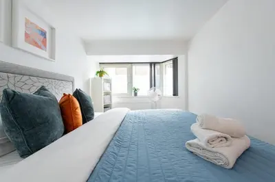 a bedroom with a bed with blue sheets and pillows at City Center,2 Bedroom Apartment with Parking in Cambridge