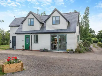 a white house with a green door at Russets in North Weald