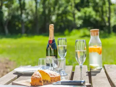 a table with wine glasses and bread and wine bottles at Russets in North Weald